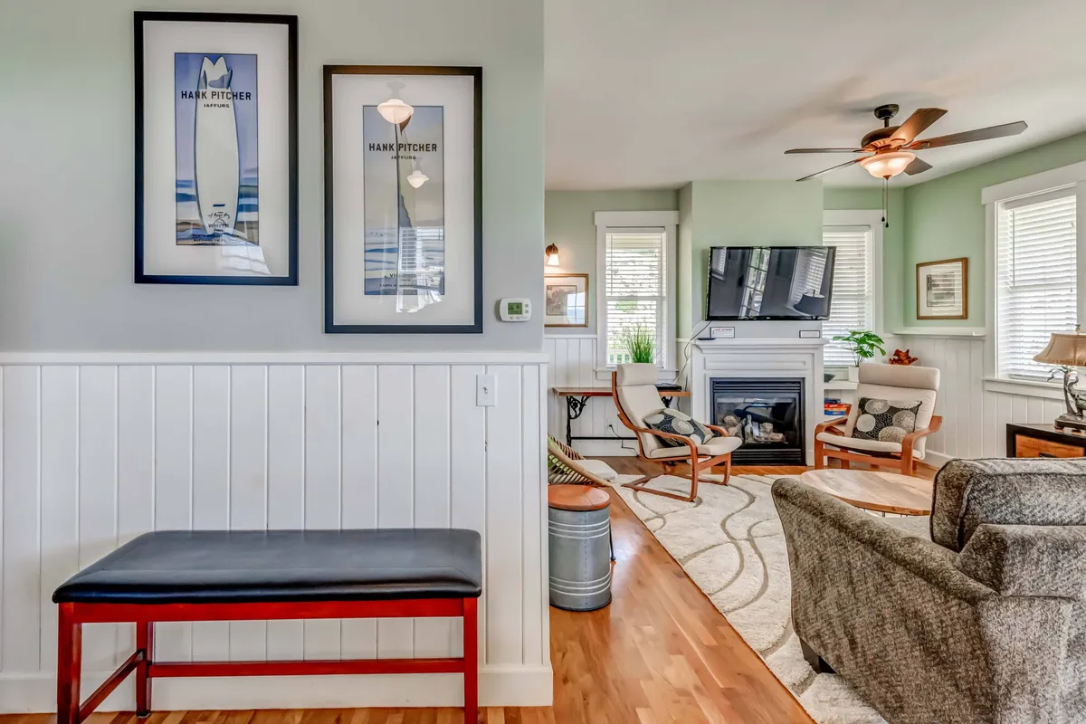 This image captures a cozy living area featuring a comfortable seating arrangement, a warm fireplace, and eye-catching artwork on the wall. The space is inviting, suggesting a welcoming place to gather with friends or family after enjoying amenities or outdoor activities.
